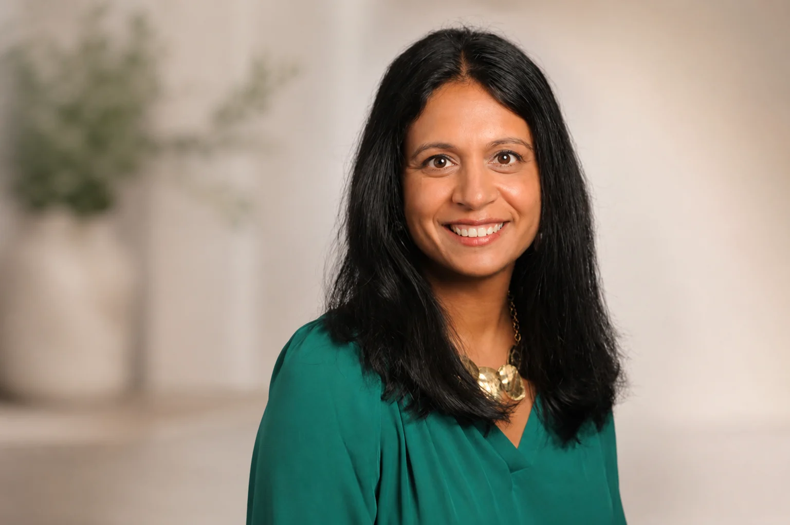 Dr. Shefali Pandya smiling in a softly lit office setting.