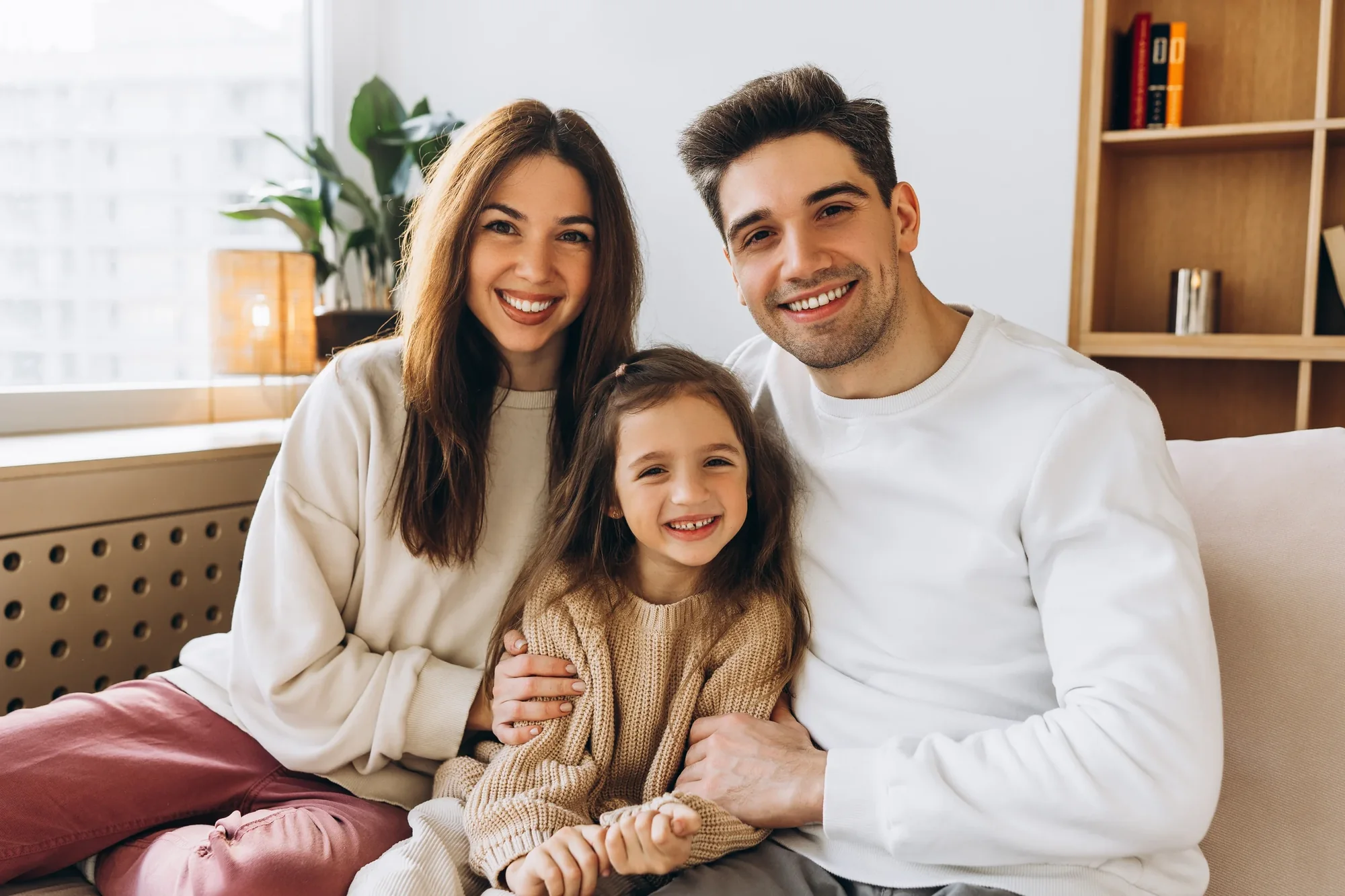 A smiling family seated together at home.