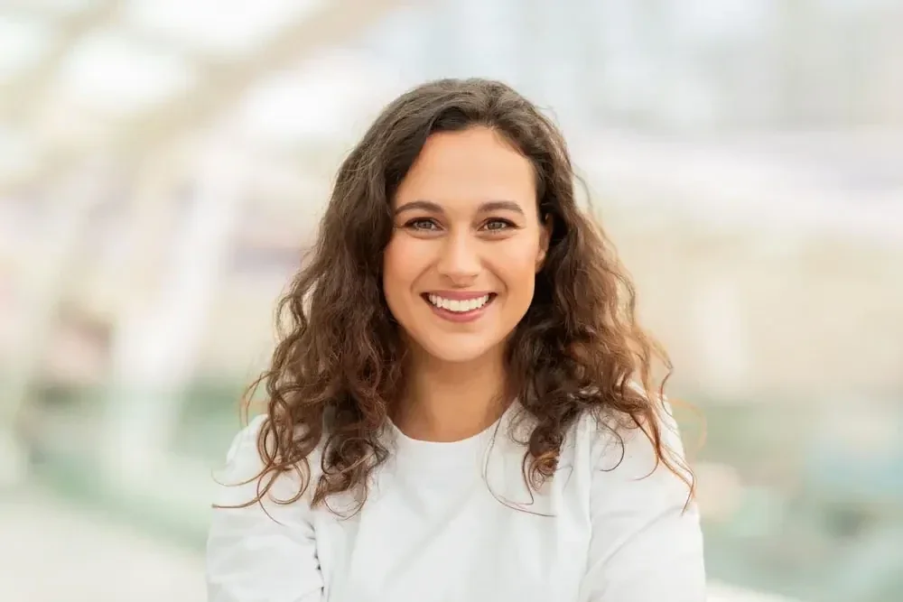 A smiling Brandywine Dental Care patient in a bright, softly lit setting.